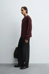 Jersey de hombre, color vino tinto, de calce regular fit, tejido en punto con algodón, cuello redondo y manga larga. Presenta acabados en rib con vuelta en cuello, puños y ruedo.