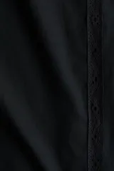 Pantalón de corte holgado en popelina de algodón, color negro, con cintura elástica y cordón de ajuste. Presenta piernas rectas, franjas de encaje en los laterales y ribete de encaje en los bajos.