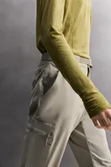 Pantalón de hombre color marrón oscuro, corte regular fit, confeccionado en tejido técnico compacto elástico. Presenta cintura ajustable con cinturón negro a contraste, bolsillos frontales, bolsillo trasero con cierre y bolsillo cargo con cierre en la pernera.