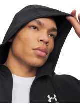 Campera deportiva Under Armour Rivl Wvn Windbreaker, color negro, con capucha, cierre frontal completo y bolsillos laterales con cremallera. Incluye el logo de la marca estampado en blanco en el pecho.