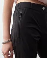 Pantalón cigarette blanco de tela techno italiana, tiro medio, cintura elastizada en la espalda, cierre y snap metálico en delantero, bolsillos laterales con cierre y recorte en la pierna con cierre en la botamanga.