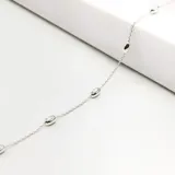 Pulsera de cadena fina en plata 925 con pequeñas cuentas metálicas ovaladas distribuidas a lo largo de toda la pieza.