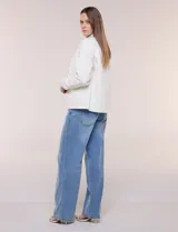 Campera de denim blanco de corte holgado con hombros caídos, cuello con solapa en contraste de color celeste, cierre frontal con botones metálicos y bolsillos delanteros con solapa.