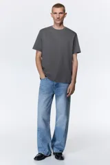 Remera gris de corte recto, cuello redondo y mangas cortas.