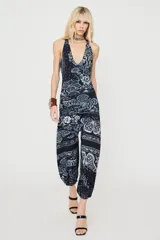 Body de escote en V profundo y tirantes halter, confeccionado con estampado en tonos oscuros con motivos florales y de mariposas.