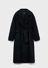 Abrigo largo de lana italiana Manteco, diseño oversize con cuello de solapa, cierre frontal de botones y cinturón desmontable. Presenta mangas largas con hebillas decorativas en los puños, dos bolsillos laterales y abertura posterior en el bajo.