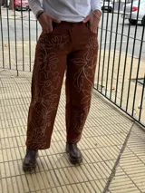 Pantalón slouchy de gabardina color marrón chocolate, tiro medio, estilo mom, con bordado floral blanco a mano.