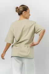 Remerón de algodón color beige, con diseño oversize, cuello redondo, mangas cortas amplias y hombros caídos.