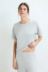Pijama de dos piezas en color gris melange, compuesto por una remera de manga corta con detalles de encaje en los bordes y un pantalón de corte recto con cintura elástica y detalle de encaje en la pretina.