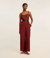 Mono de mujer color rojo oscuro (bordó) con escote corazón, breteles anchos con elástico y piernas rectas con pliegues frontales.