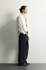 Camisa relaxed fit de algodón con estructura, cuello solapa, manga larga con puño abotonado, bolsillo de parche en el pecho y cierre frontal con botones. Presenta diseño de rayas finas.