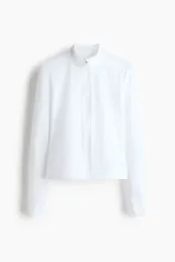 Campera deportiva de mujer en tejido funcional color blanco, corte ajustado, cuello elevado, cierre frontal y mangas largas con abertura para el pulgar.