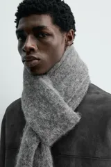 Bufanda de punto tejida en hilatura con mezcla de fibra de alpaca, de textura suave y diseño rectangular.