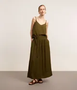 Pollera midi evasé color verde militar, confeccionada en crepé. Cuenta con cintura ancha elástica en la parte trasera, trabillas en los laterales y cinturón de cuerda incorporado con abalorios en las puntas.