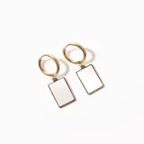 Aros de acero enchapado en oro con forma de argolla y dije rectangular de nácar.