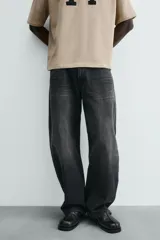 Jeans de hombre, corte balloon fit, tiro medio, confeccionados en denim rígido de algodón. Presentan un efecto lavado con un marcado degradado vertical, cinco bolsillos y cierre frontal con cremallera y botón.