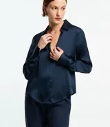 Camisa de manga larga con cuello inglés y botones frontales, confeccionada en satén liso de color azul marino.