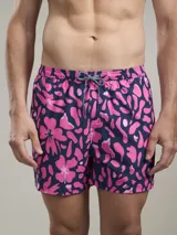 Short de baño con estampado floral abstracto en tonos rosa sobre fondo azul marino. Cuenta con cintura elástica con cordón ajustable y red interior para mayor soporte.