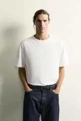 Camiseta relaxed fit color blanco, de cuello redondo y manga corta. Presenta un pequeño parche aplicado a contraste en el extremo de la manga y terminaciones en rib.