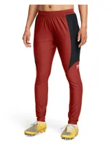 Pantalón deportivo Under Armour de corte ajustado, diseñado para fútbol. Presenta un diseño bicolor en rojo y negro con cintura elástica y cordón de ajuste interno. Incluye tecnología de secado rápido y tejido elástico en cuatro direcciones para mayor movilidad.