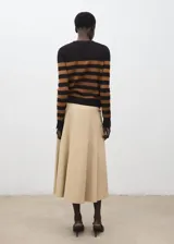 Cardigan de punto fino color negro con franjas horizontales tostadas, de cuello redondo, manga larga y cierre frontal con botones dorados.