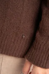 Cardigan de tejido de punto grueso color marrón oscuro, con escote en V y cierre frontal de botones redondos color hueso. Presenta un diseño texturado con líneas verticales marcadas.