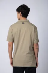 Chomba de manga corta en color blanco, con cuello clásico y cierre frontal de dos botones. Presenta un corte recto y diseño minimalista.