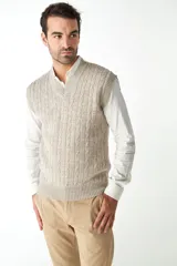 Chaleco de punto color beige con diseño de trenzas, escote en V y sisas amplias.