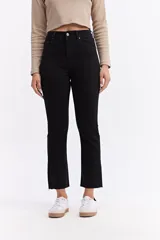 Jean de corte recto y tiro alto, color negro, con terminación de ruedo desflecado y largo crop.