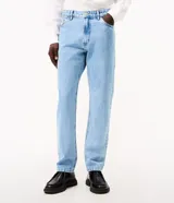 Pantalón de jean corte slim, color azul claro con lavado stonewash, con cierre frontal de botón y cremallera, presillas para cinturón y bolsillos funcionales.