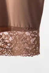 Falda corta de tiro bajo, color marrón satinado, con cintura elástica y bajo acabado con aplicación de encaje a tono.