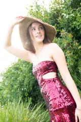 Vestido corto negro con diseño cut-out en la cintura, estilo strapless y ruedo decorado con flecos largos.