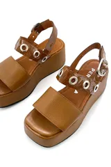 Sandalia de cuero color marrón con plataforma y ajuste con hebilla.