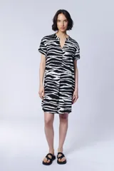 Vestido camisero corto con estampado de cebra en blanco y negro, cuello mao y mangas cortas.