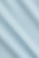 Remera de manga corta en punto acanalado de viscosa, de color celeste, con corte entallado, cuello redondo fino y detalle de ribete de encaje en las terminaciones de las mangas.