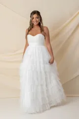 Vestido largo de fiesta color blanco, strapless, con corsé drapeado y falda amplia con volados de tul. Ideal para novias.