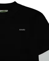 Remera de diseño doble capa con cuerpo negro de algodón y mangas largas tejidas en color blanco. Presenta un corte boxy relajado, cuello redondo y el logo de la marca estampado en pequeño en el pecho.