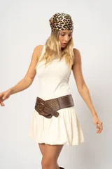 Vestido corto color crema, sin mangas, con cuello redondo y falda con volumen.