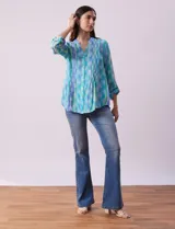 Blusa de gasa estampada multicolor, marca Ruby Rd. Tiene cuello a la base, escote en V, abertura central con botones y plisados en la parte delantera. Las mangas son 3/4 y tienen un largo regulable con presilla y botón.