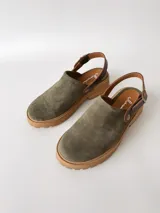 Zuecos de cuero color verde seco, con hebilla lateral y suela de goma.