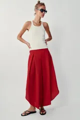 Pantalón fluido de tiro alto en color blanco, con pinzas delanteras, cintura elástica en la espalda y perneras anchas con aberturas laterales pronunciadas.