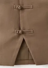 Chaleco marrón de mezcla de algodón y lino, con cuello redondo, sin mangas y cierre delantero con botones tipo nudo chino.