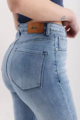 Pantalón de jean celeste de corte acampanado, tiro alto y ruedo desflecado.