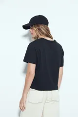 Remera blanca de manga corta con cuello redondo, aberturas laterales y bordado frontal con la frase "LIMITED EDITION" en negro.