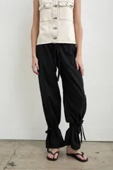 Pantalón recto marrón de lino y algodón, con tiras regulables en los tobillos para ajustar.