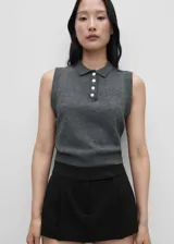 Chaleco de punto fino en color gris, con diseño recto, cuello camisero y cierre frontal parcial con botones. Sin mangas.