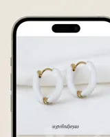 Aros tipo argolla pequeña de acero dorado con recubrimiento esmaltado en color blanco.