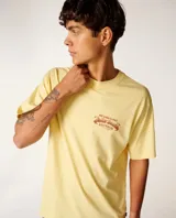 Remera de manga corta color amarillo ocre, corte holgado y diseño con estampa gráfica en el pecho y en la espalda.