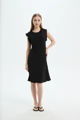Vestido midi de poliéster color blanco, de corte recto y escote redondo a la base, con mangas cortas abuchonadas con volados y detalles de volados en el ruedo.