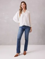 Jean de corte recto y tiro medio, confeccionado en denim azul con efecto lavado. Presenta cierre frontal con botón, pasadores para cinturón y diseño clásico de cinco bolsillos.